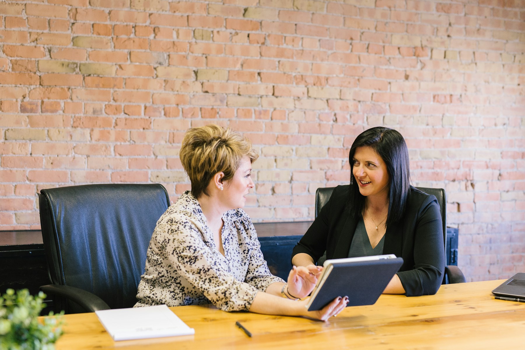 Two business professionals in conversation at a meeting table